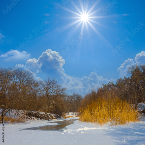 melting frozen river at sunny day, winter natural background
