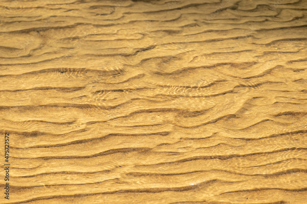 Golden sand under water during sunset as background Golden sand under water during sunset as background