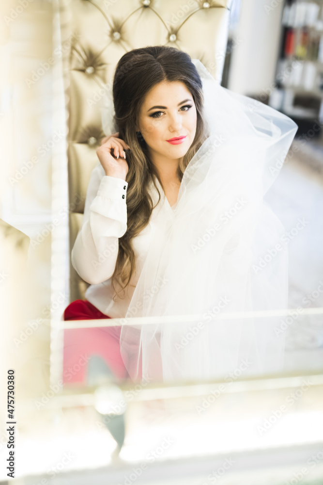 Gorgeous bride in robe posing and preparing for the wedding ceremony face in a room Gorgeous bride in robe posing and preparing for the wedding ceremony face in a room