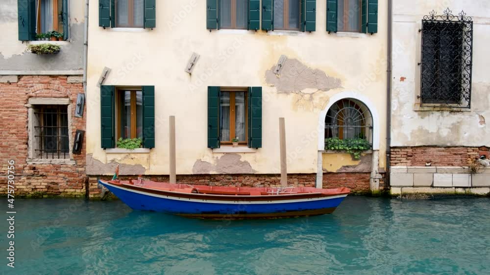Small boat rocking on the water canal in the old town of Italian city of Venice Small boat rocking on the water canal in the old town of Italian city of Venice
