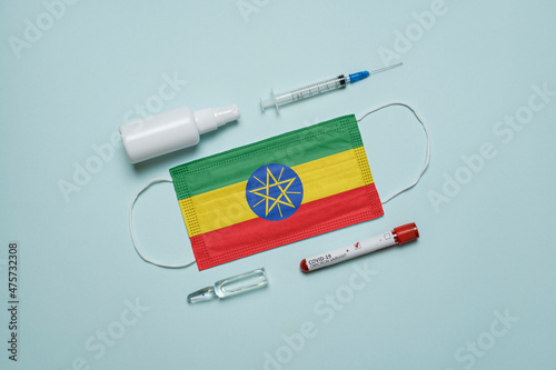 Blood tube for test detection of virus Covid-19 Omicron Variant with positive result, medicine mask with Ethiopia flag superimposed and vaccine.  New Variant of the Covid-19 Omicron