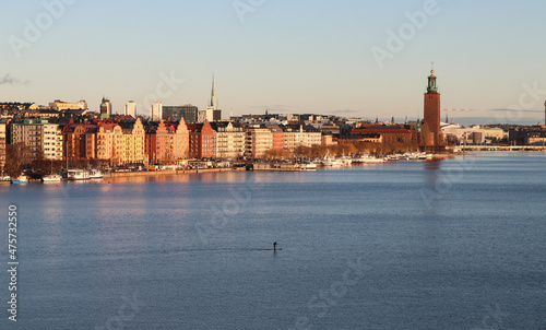 Photography Paddle-boarder sailing the central Stockholm river at sunset, in Sweden