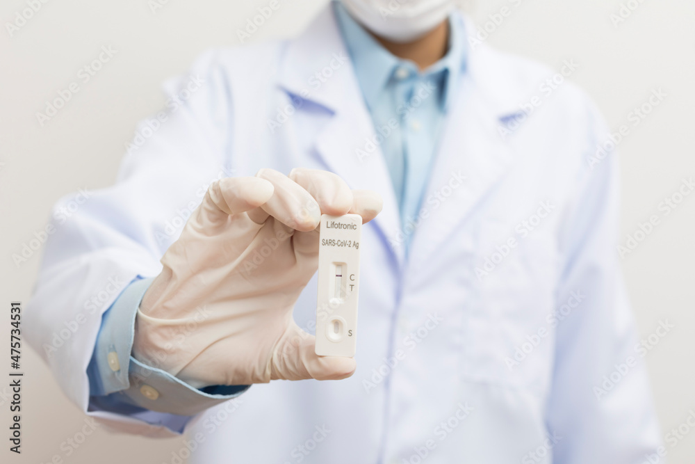 The doctor showing Covid-19 negative test result of the antigen rapid test kit on white background,Coronavirus infectious protect concept. The doctor showing Covid-19 negative test result of the antigen rapid test kit on white background,Coronavirus infectious protect concept.
