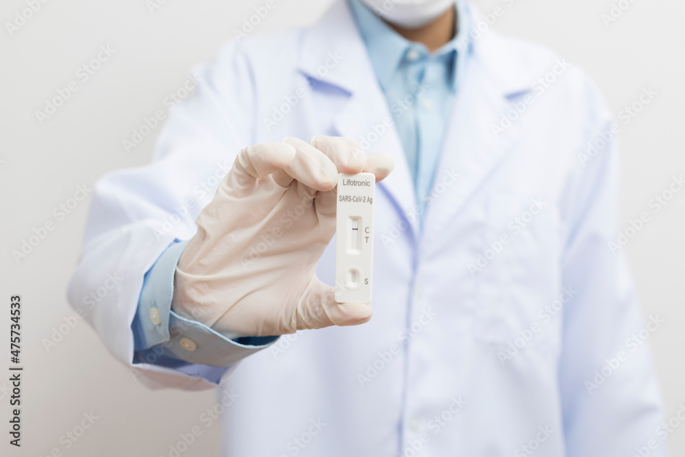 The doctor showing Covid-19 negative test result of the antigen rapid test kit on white background,Coronavirus infectious protect concept. The doctor showing Covid-19 negative test result of the antigen rapid test kit on white background,Coronavirus infectious protect concept.