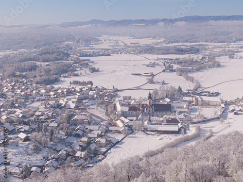 AERIAL: Drone point of view of a picturesque snowy town in rural Slovenia.