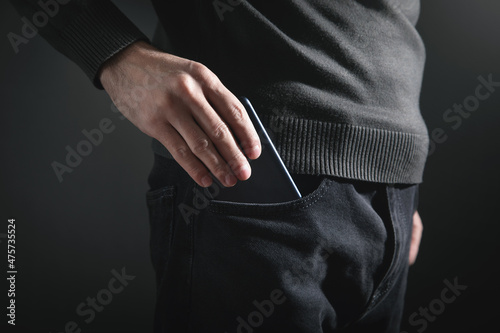Man putting smartphone in pocket of jeans. © andranik123