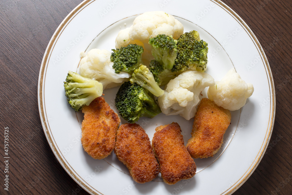 Dinner on a white plate that is on a dark background Dinner on a white plate that is on a dark background