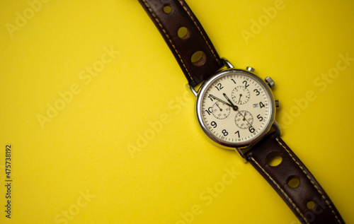 Classic men's watch with a leather strap showing five minutes to midnight. 5 minutes to twelve o'clock