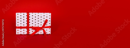 Christmas gift box witn red bow. Sale, Valentine day, black friday, cyber monday, New year concept, top view, flat lay, isolated, copy space on minimal red background © makanna