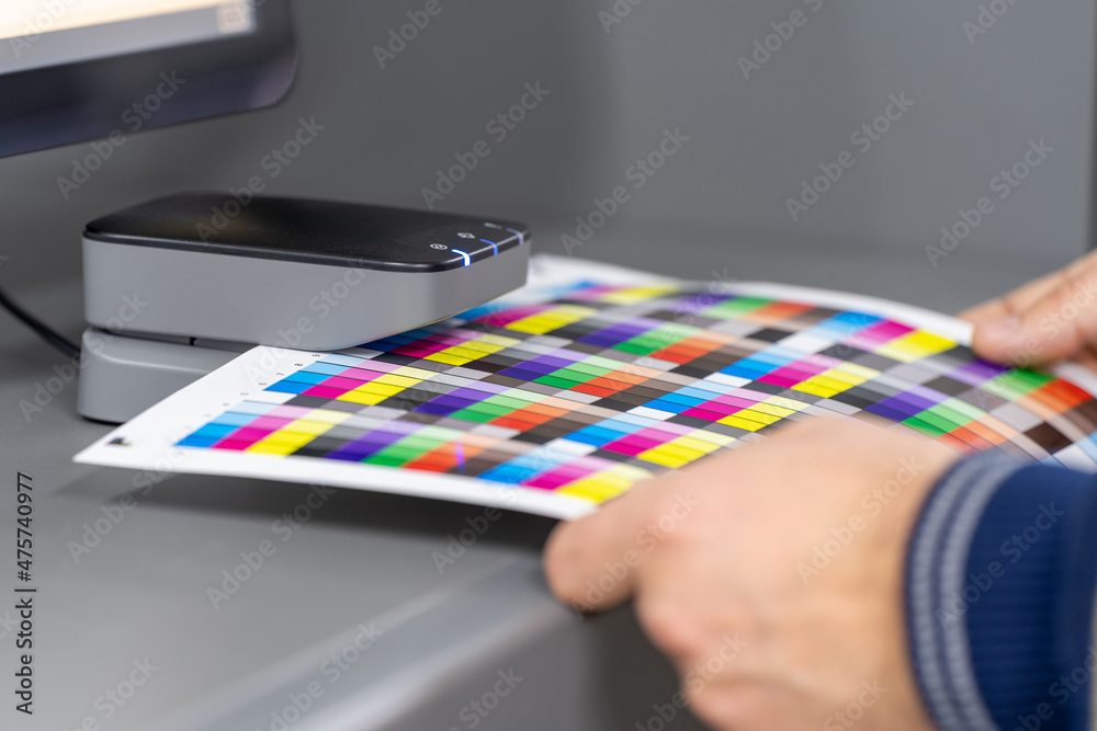 Set-up digital printing press for production. Paper measuring and color calibration.
