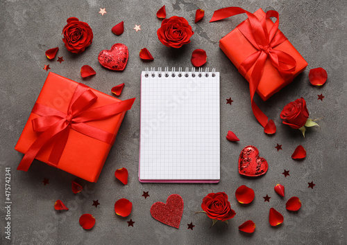 Romantic composition with empty notebook and gifts on grunge background