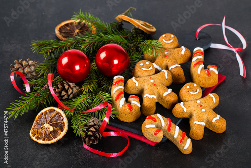 Fototapeta Naklejka Na Ścianę i Meble -  Christmas Gingerbread Man. Holiday  honey ginger cookies with cinnamon and nutmeg on a serving board on a red linen napkin on a dark background