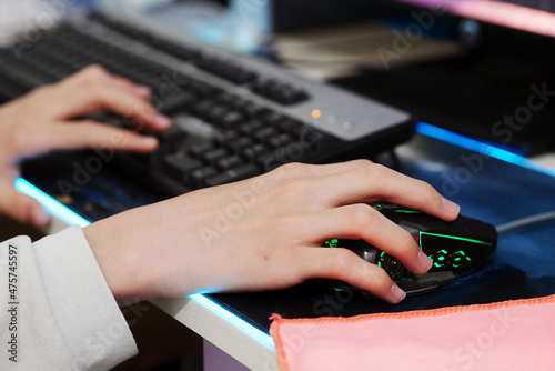 a person using a computer mouse, a person playing a game on a desktop computer using a mouse,