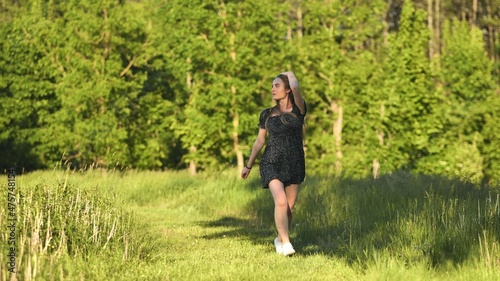 A young girl runs in a meadow on a warm summer evening.