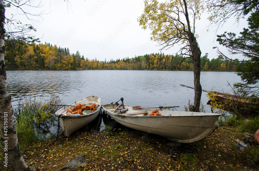 Wooden boats on the shore of an autumn lake 