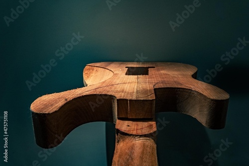 Wooden electric guitar's body unfinished on dark background