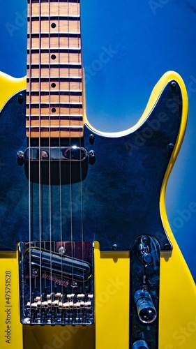 Yellow black electric guitar on colored background