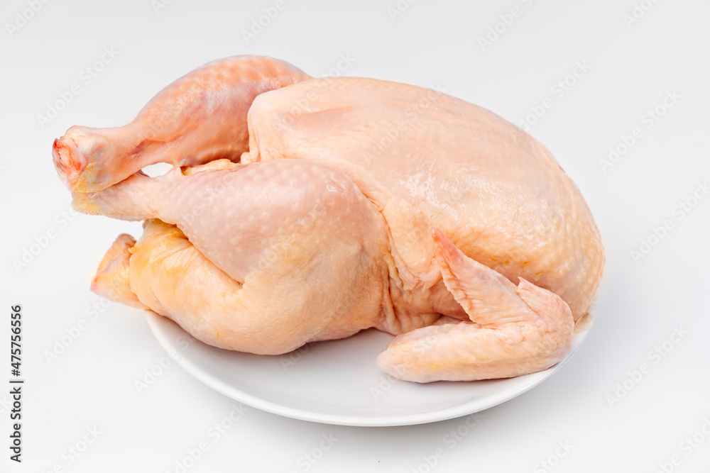 carcass of raw chicken on a white plate on a white background. carcass of raw chicken on a white plate on a white background.