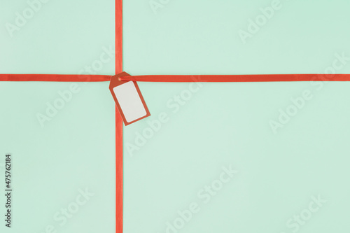 Creative arrangement made of decorative ribbon and label. Minimal gift concept. Christmas and New Year inspiration.