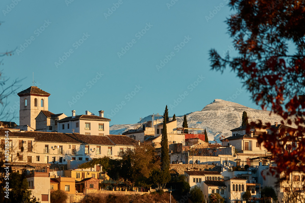 View of the Albaicin neighborhood of Granada (Granada) at sunset with the snow-capped peaks of Sierra Nevada in the background