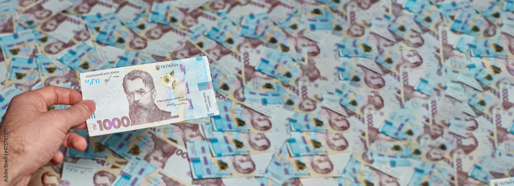 Ukrainian money. Background of Ukrainian money. Banner of banknotes. The hand holds the Ukrainian 1000 hryvnia.