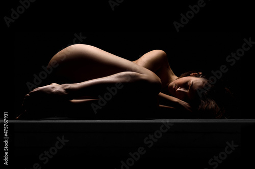 Nude woman sensual sleeping isolated on black 