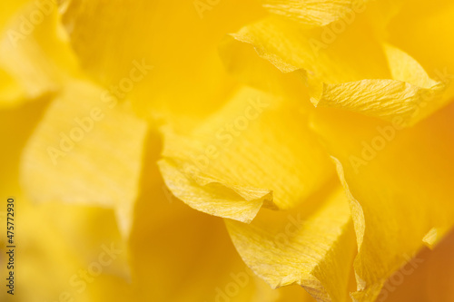 Fragment of a yellow flower made of crepe paper. Macro photography. Soft selective focus
