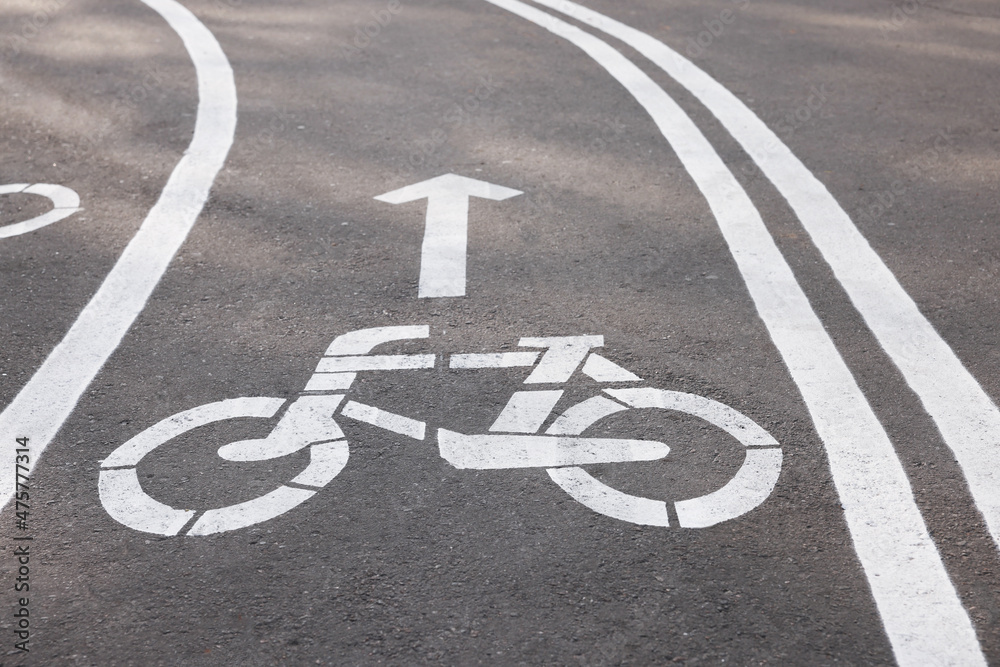 Obraz premium Bicycle lane with sign and arrow pointing direction on asphalt