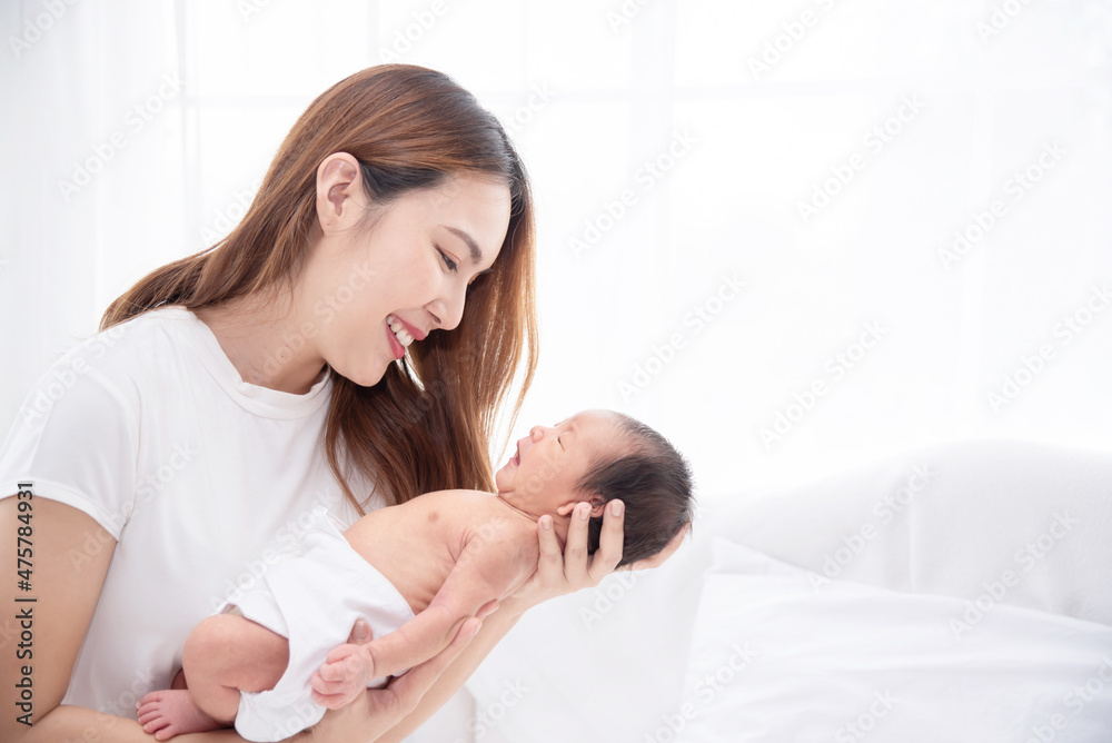 Asian loving mom carying of her newborn baby at home. Happy mum holding sleeping infant child on hands. Mother hugging her little one months old son. Asian loving mom carying of her newborn baby at home. Happy mum holding sleeping infant child on hands. Mother hugging her little one months old son.