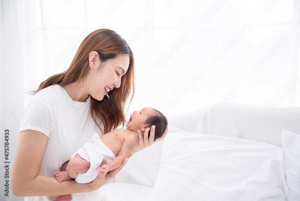 Asian loving mom carying of her newborn baby at home. Happy mum holding sleeping infant child on hands. Mother hugging her little one months old son. Asian loving mom carying of her newborn baby at home. Happy mum holding sleeping infant child on hands. Mother hugging her little one months old son.