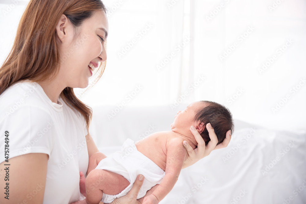 Asian loving mom carying of her newborn baby at home. Happy mum holding sleeping infant child on hands. Mother hugging her little one months old son. Asian loving mom carying of her newborn baby at home. Happy mum holding sleeping infant child on hands. Mother hugging her little one months old son.