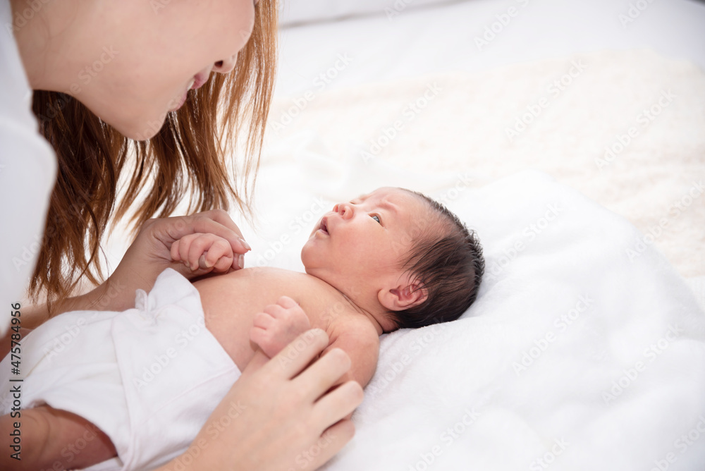 Asian loving mom carying of her newborn baby at home. Happy mum holding sleeping infant child on hands. Mother hugging her little one months old son. Asian loving mom carying of her newborn baby at home. Happy mum holding sleeping infant child on hands. Mother hugging her little one months old son.