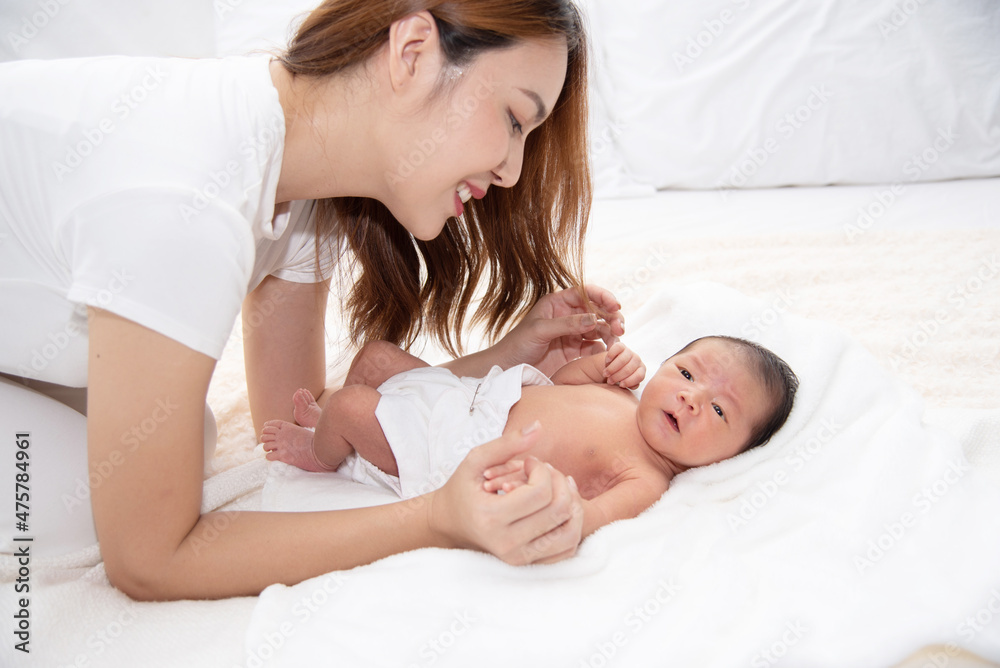 Asian loving mom carying of her newborn baby at home. Happy mum holding sleeping infant child on hands. Mother hugging her little one months old son. Asian loving mom carying of her newborn baby at home. Happy mum holding sleeping infant child on hands. Mother hugging her little one months old son.