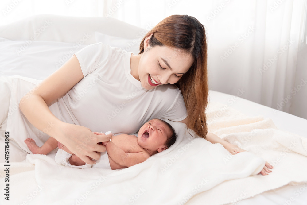 Asian loving mom carying of her newborn baby at home. Happy mum holding sleeping infant child on hands. Mother hugging her little one months old son. Asian loving mom carying of her newborn baby at home. Happy mum holding sleeping infant child on hands. Mother hugging her little one months old son.