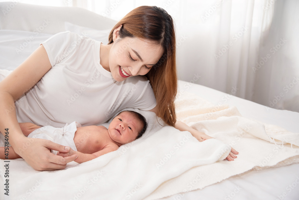 Asian loving mom carying of her newborn baby at home. Happy mum holding sleeping infant child on hands. Mother hugging her little one months old son. Asian loving mom carying of her newborn baby at home. Happy mum holding sleeping infant child on hands. Mother hugging her little one months old son.