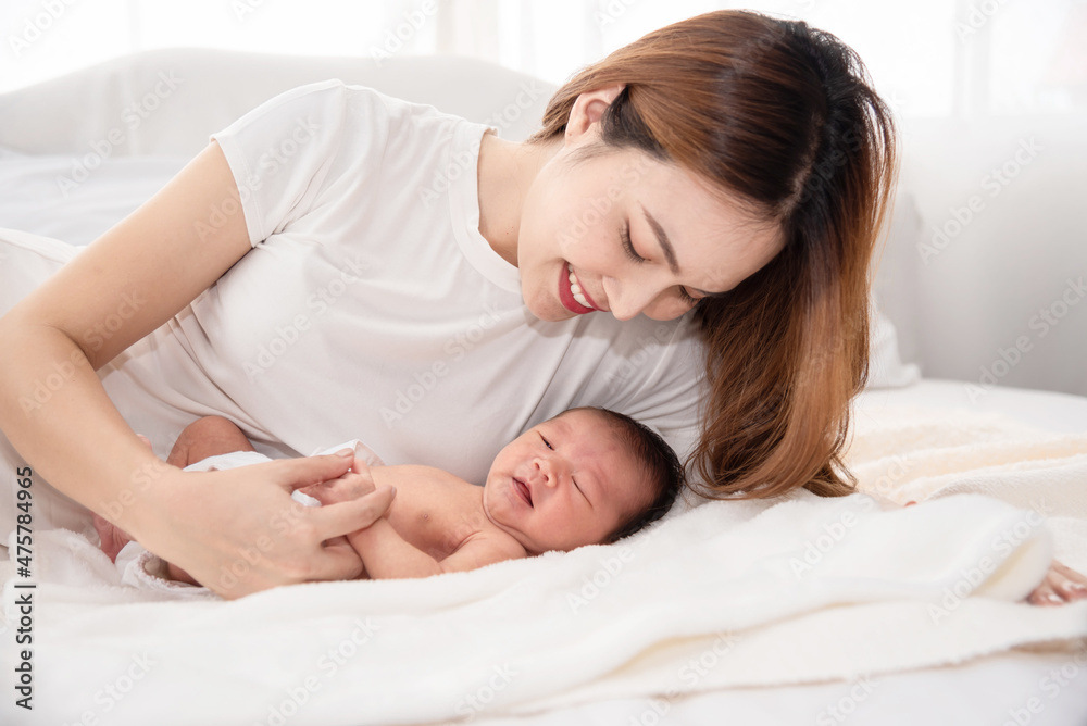 Asian loving mom carying of her newborn baby at home. Happy mum holding sleeping infant child on hands. Mother hugging her little one months old son. Asian loving mom carying of her newborn baby at home. Happy mum holding sleeping infant child on hands. Mother hugging her little one months old son.