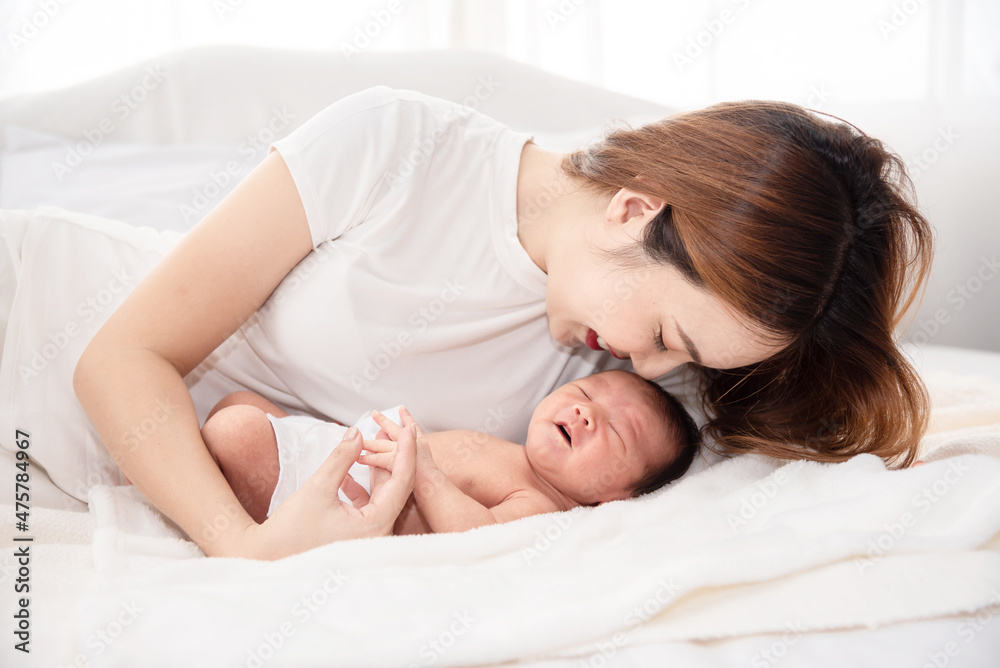 Asian loving mom carying of her newborn baby at home. Happy mum holding sleeping infant child on hands. Mother hugging her little one months old son. Asian loving mom carying of her newborn baby at home. Happy mum holding sleeping infant child on hands. Mother hugging her little one months old son.