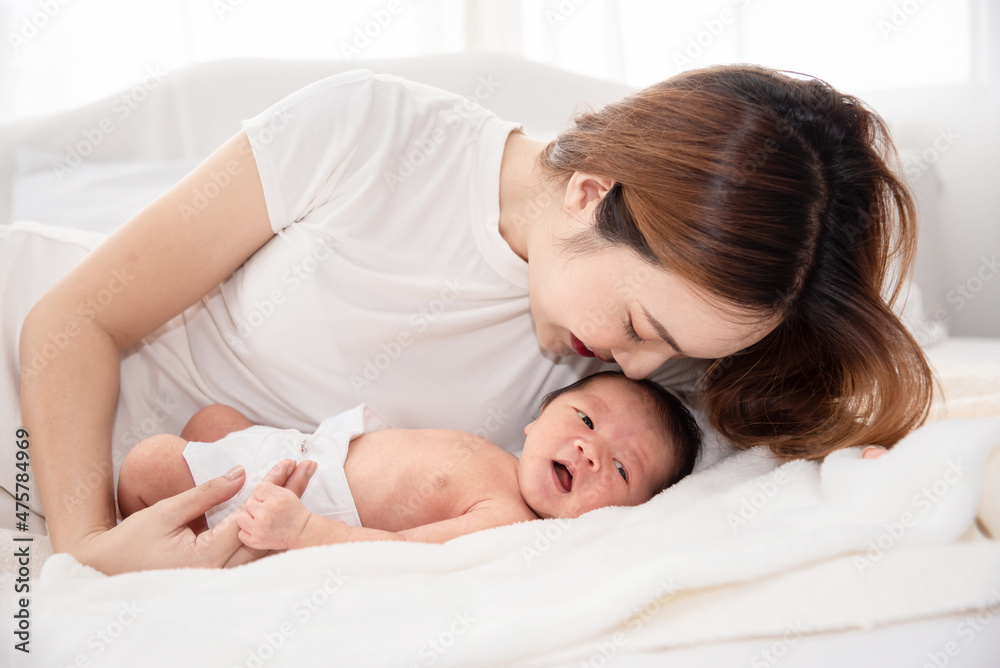 Asian loving mom carying of her newborn baby at home. Happy mum holding sleeping infant child on hands. Mother hugging her little one months old son. Asian loving mom carying of her newborn baby at home. Happy mum holding sleeping infant child on hands. Mother hugging her little one months old son.