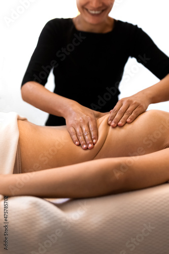 Happy masseuse working on female client mid back enjoying her job. Woman receiving massage relaxing in spa.