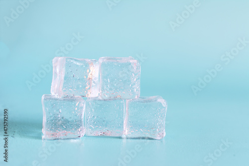 Transparent ice cubes with water drops on a light background close-up. Background of transparent ice cubes close-up and.