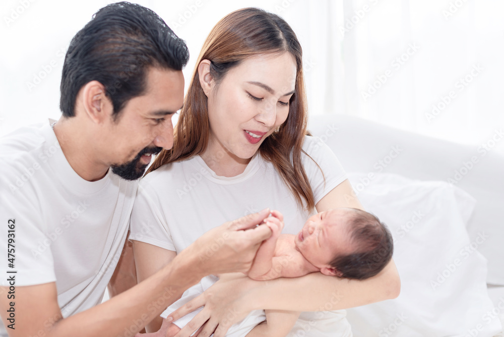 Happay family with newborn child. Newly father and mother excited having first baby, family holding and smiling to their baby. Happay family with newborn child. Newly father and mother excited having first baby, family holding and smiling to their baby.