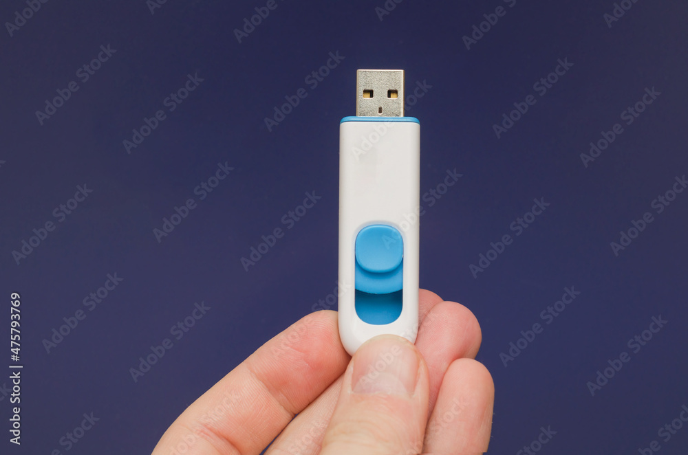 plastic usb stick for pc in hand on purple blue background plastic usb stick for pc in hand on purple blue background