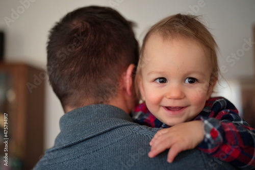 Portrait of cute little boy in his father arms