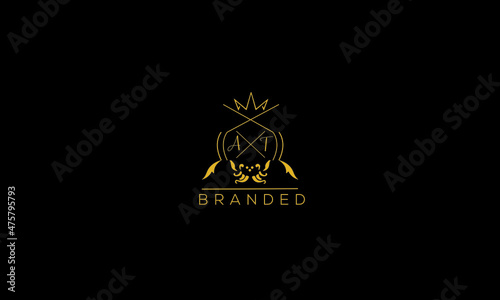 AT is a branded luxury logo with golden color and black background.