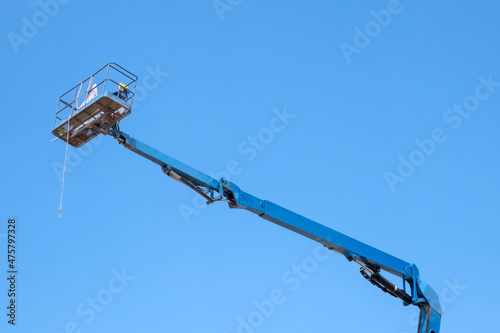 Boom lift or rerial work platform on blue sky background.
