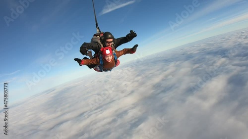 Skydiving. Tandem jump. A girl and her instructor are flying in the winter sky.