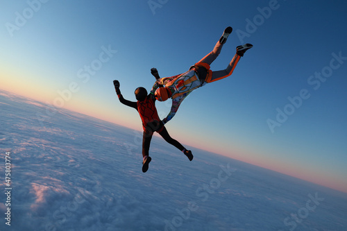 Skydiving. Sunset jump. Two skydivers are in the sky.