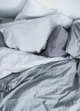 Gray bed linen. The weakening atmosphere, minimalism. Folds, drapes, natural cotton. Cozy bedroom.	