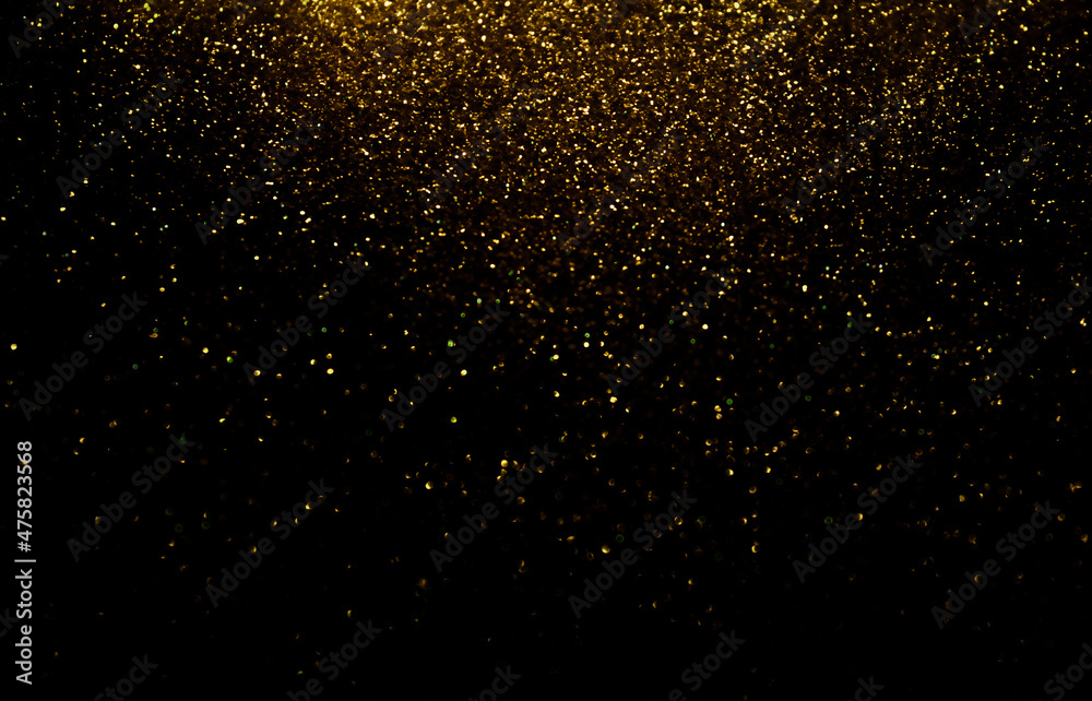 Defocused Glittery Golden Lights over Dark Background