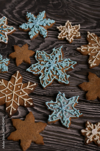 Gingerbread cookies in the shape of a snowflake. Decorated with sugar glaze. Gingerbread cookies in the shape of a snowflake. Lie on black boards. Close-up shot.